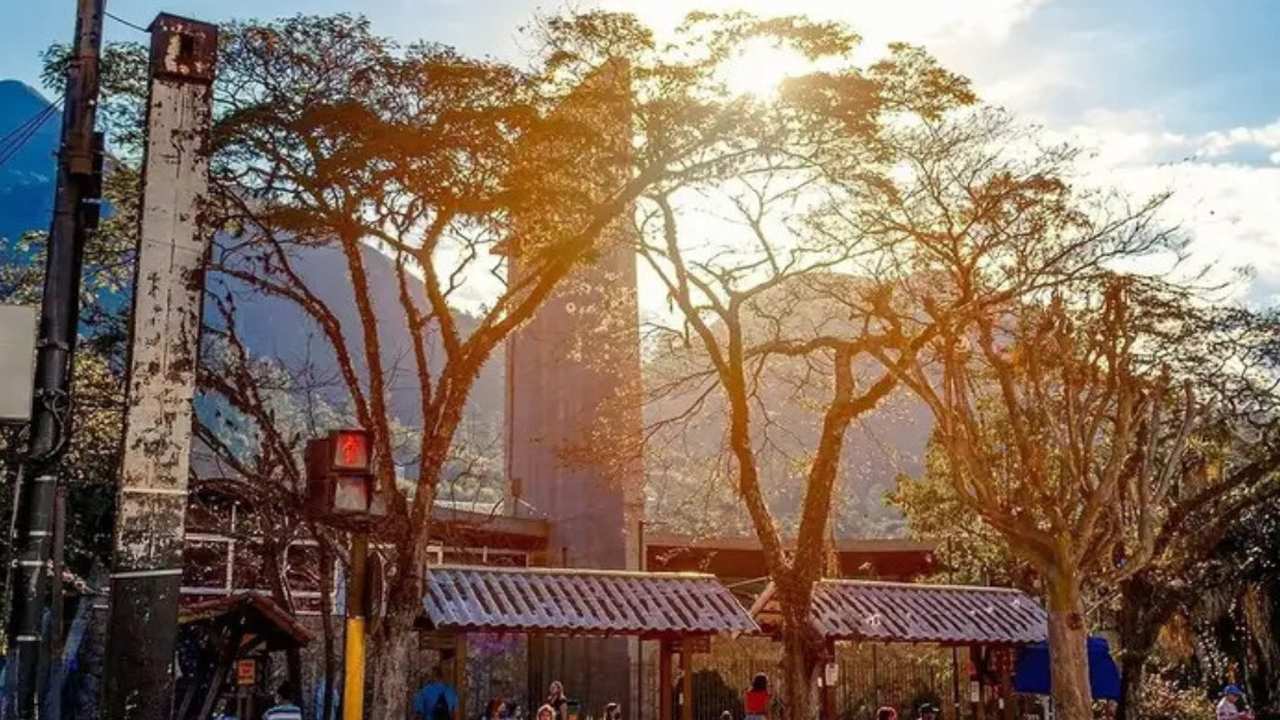Foto de Nova Friburgo com árvores, construções e céu ensolarado. Possível impacto de novas leis.