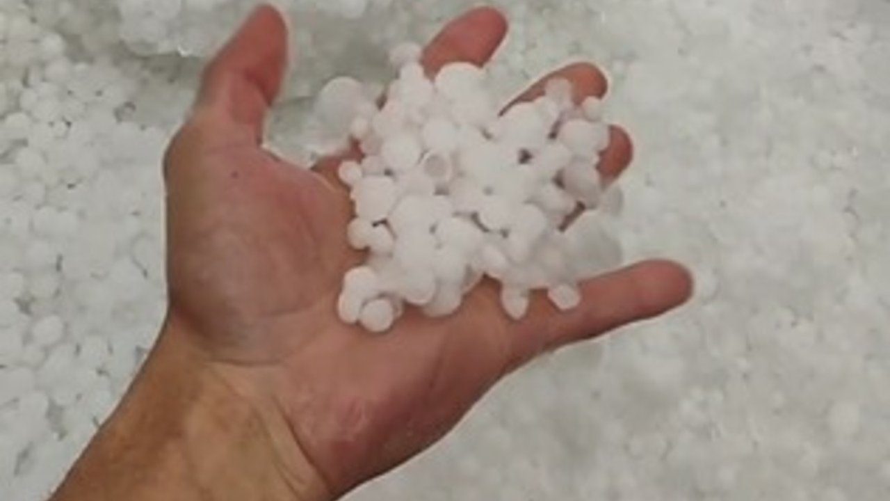 Granizo sendo segurado em uma mão, com um fundo de mais granizo.
