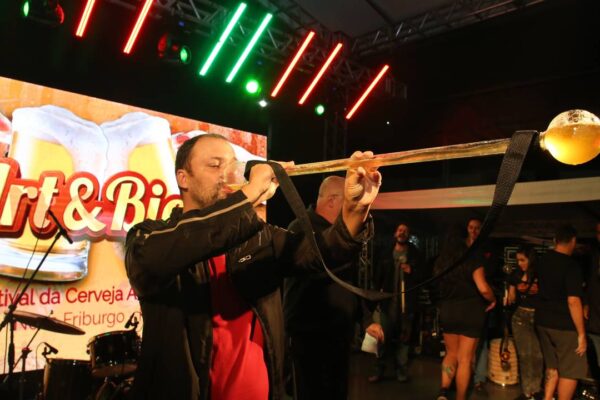 Homem bebe cerveja em evento comemorativo.