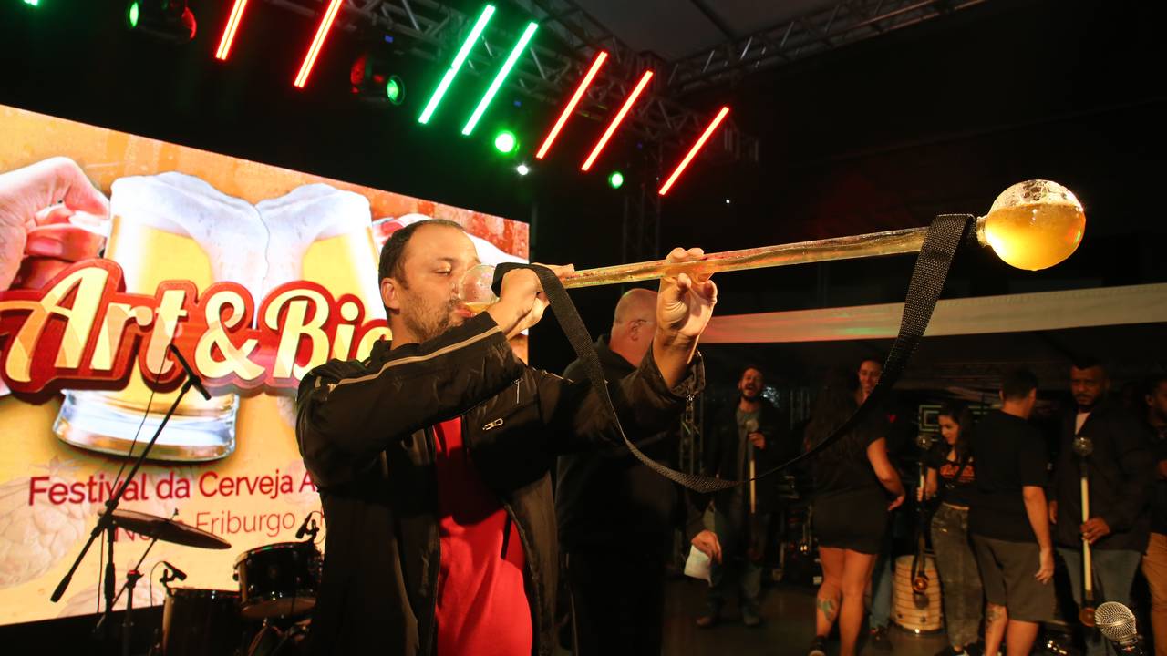 Homem bebe cerveja em evento comemorativo.