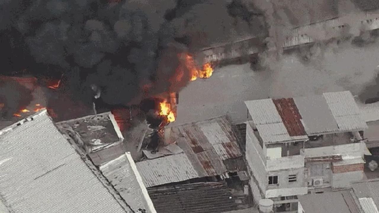 Incêndio em galpão de motopeças em Ramos, Rio de Janeiro. Fumaça e chamas intensas.