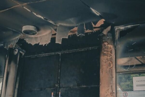 Interior de posto de saúde danificado por incêndio criminoso, com teto e estrutura destruídos.