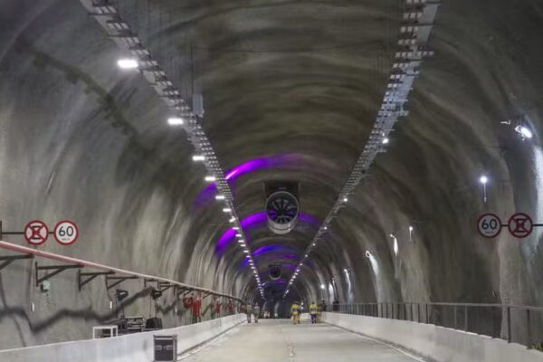 Interior de túnel rodoviário com iluminação e sinalização. Sinalização de velocidade 60 km/h.