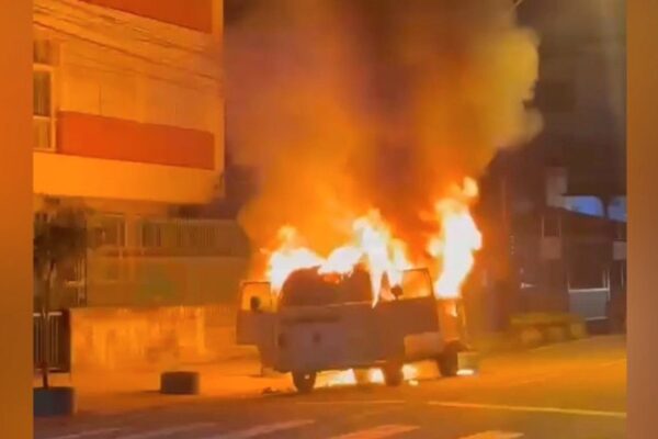 Kombi em chamas após incêndio em Nova Friburgo, Brasil. Incidente causou comoção.
