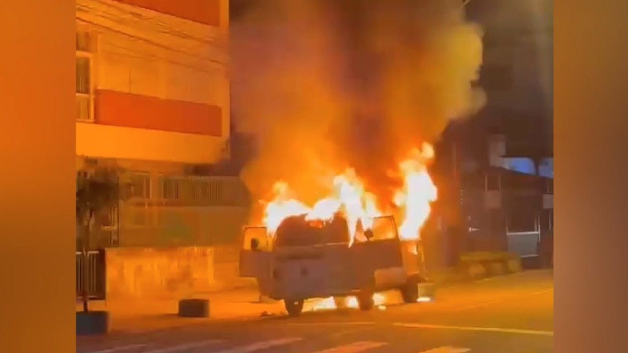Kombi em chamas após incêndio em Nova Friburgo, Brasil. Incidente causou comoção.
