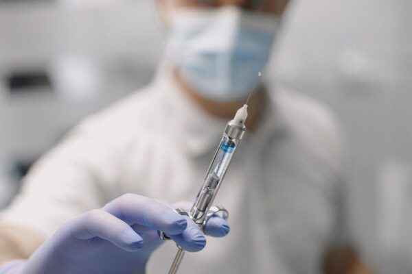 Médico com seringa em hospital, contexto de ação judicial por improbidade.