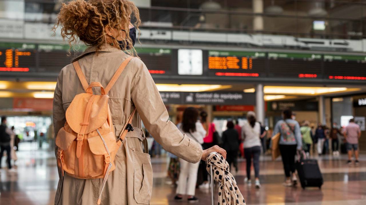 Mulher com máscara e mochila em aeroporto, possivelmente alvo de abordagem.