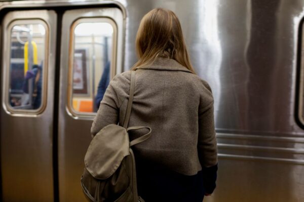 Mulher espera o metrô no Rio de Janeiro, com o preço da passagem em R$ 8,20.