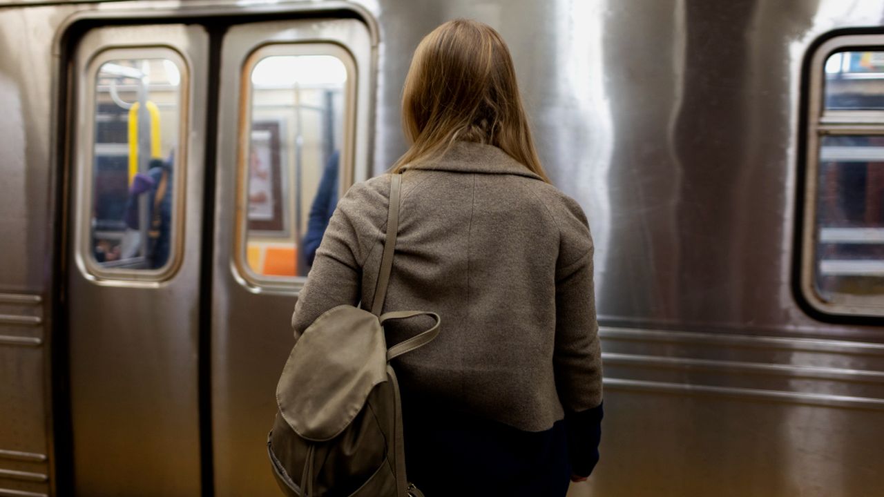 Mulher espera o metrô no Rio de Janeiro, com o preço da passagem em R$ 8,20.