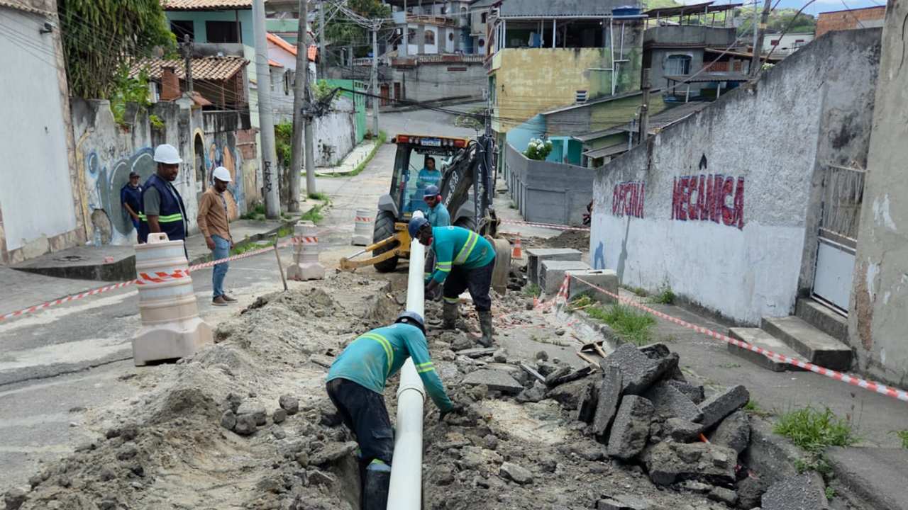 Obras em rua com encanadores instalando tubulação.
