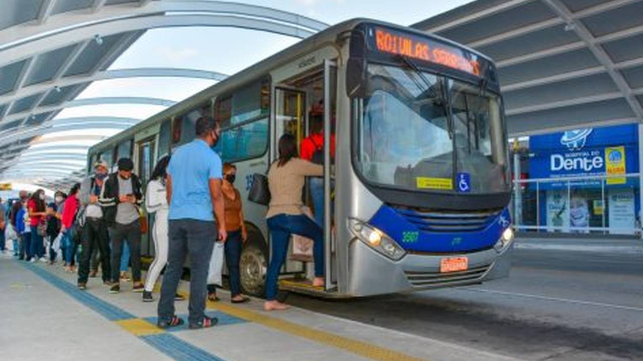 Ônibus com pessoas embarcando, refletindo debate sobre vale-transporte e custo de vida.
