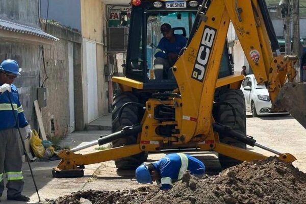 Operários trabalhando com máquinas em obra de saneamento básico no Rio de Janeiro.