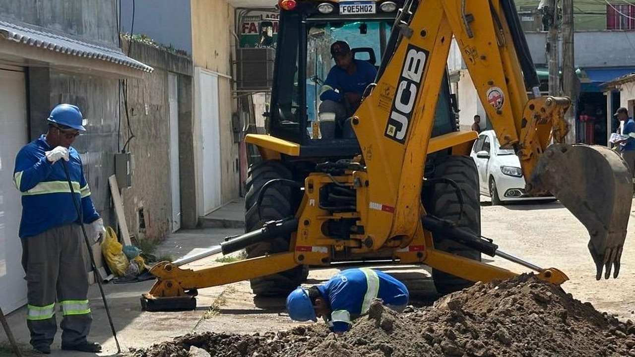 Operários trabalhando com máquinas em obra de saneamento básico no Rio de Janeiro.
