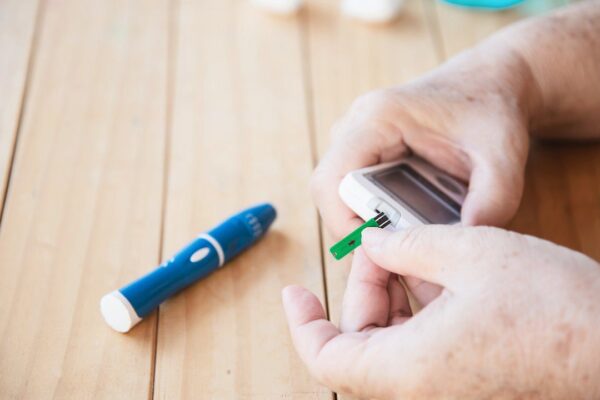 Paciente medindo glicose com glicosímetro, testando nível de açúcar no sangue. Problemas no tratamento.