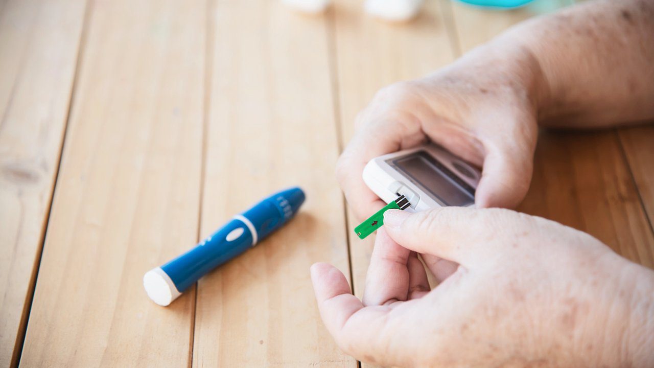 Paciente medindo glicose com glicosímetro, testando nível de açúcar no sangue. Problemas no tratamento.