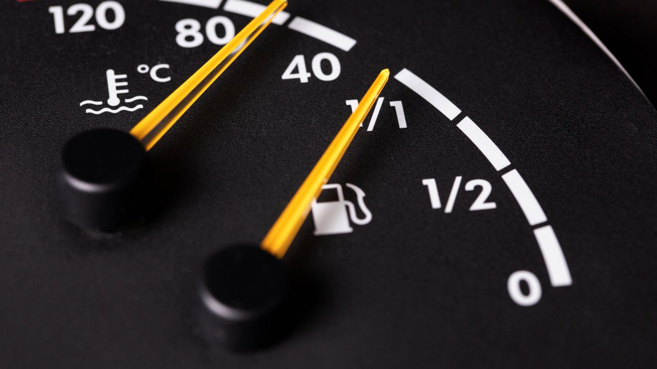 Painel de veículo mostrando temperatura e nível de combustível.