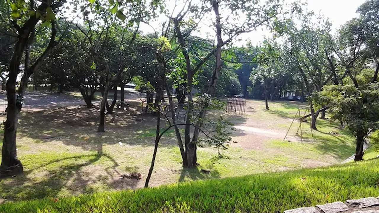 Parque Ary Barroso na Penha, Rio de Janeiro, com árvores e gramado.