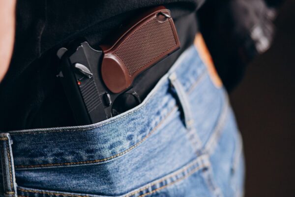 Pistola na cintura sob calça jeans