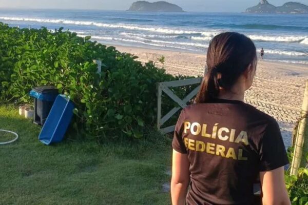 Policial Federal na praia observa área com suspeita de ocupação irregular.