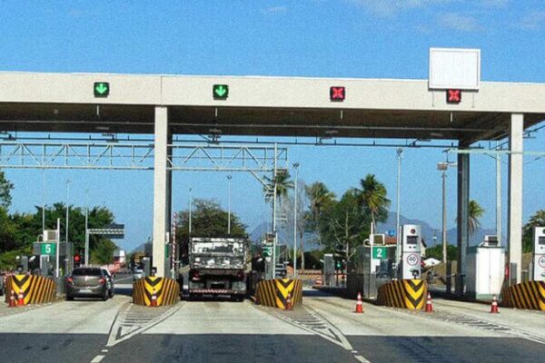 Praça de pedágio na BR-101 com placas indicativas e carros