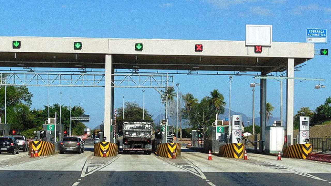 Praça de pedágio na BR-101 com placas indicativas e carros
