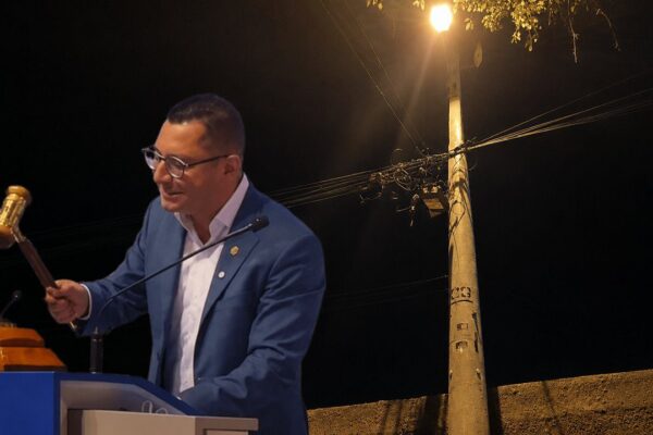 Prefeito Johnny Maycon com martelo, anunciando privatização da iluminação pública.