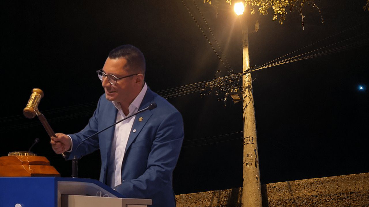 Prefeito Johnny Maycon com martelo, anunciando privatização da iluminação pública.