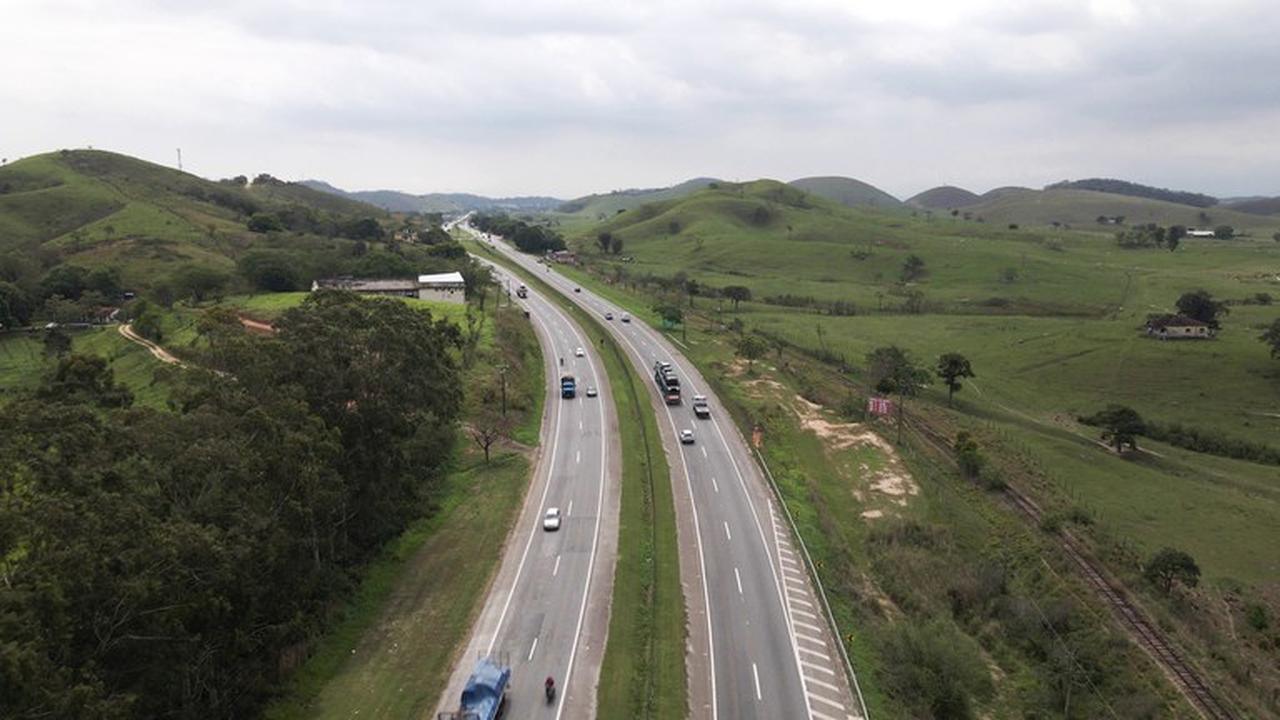 Rodovia BR-101 com obras de modernização no Rio de Janeiro, com veículos e paisagem verde.
