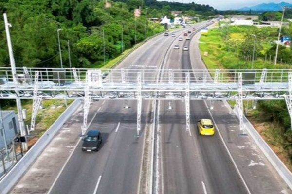 Rodovia com sistema free flow, sem barreira física, com carros passando.