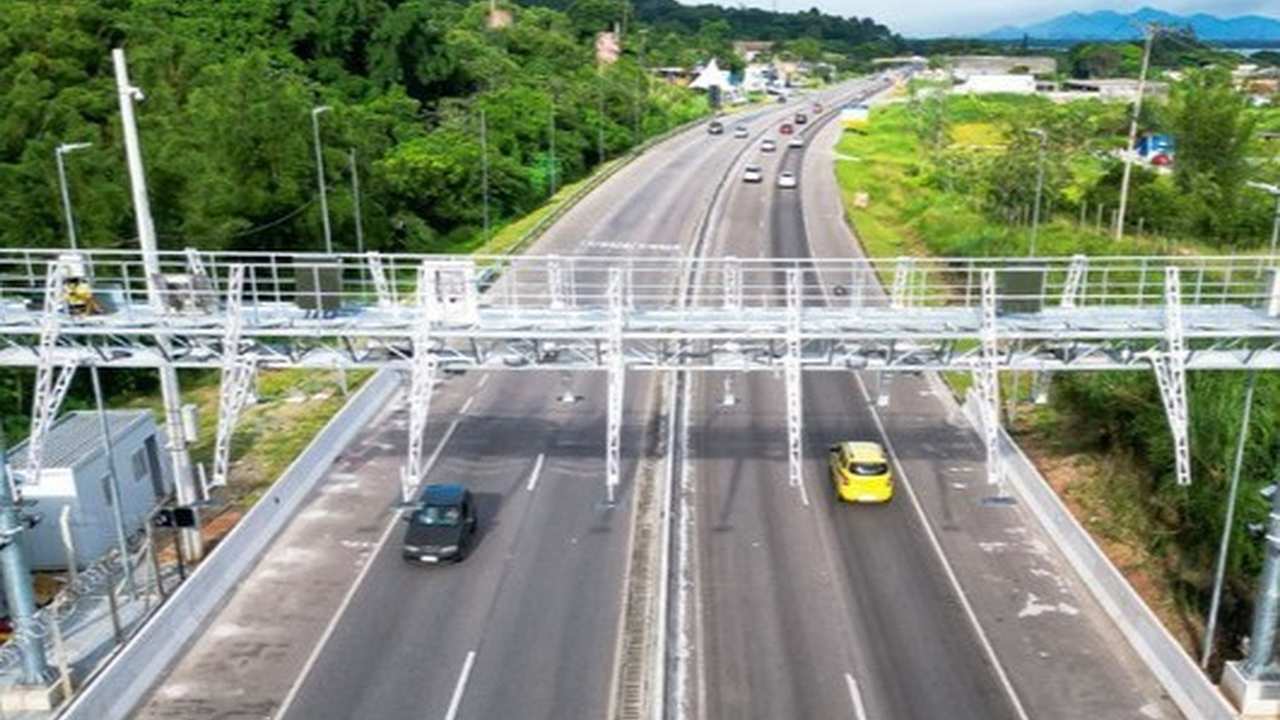 Rodovia com sistema free flow, sem barreira física, com carros passando.