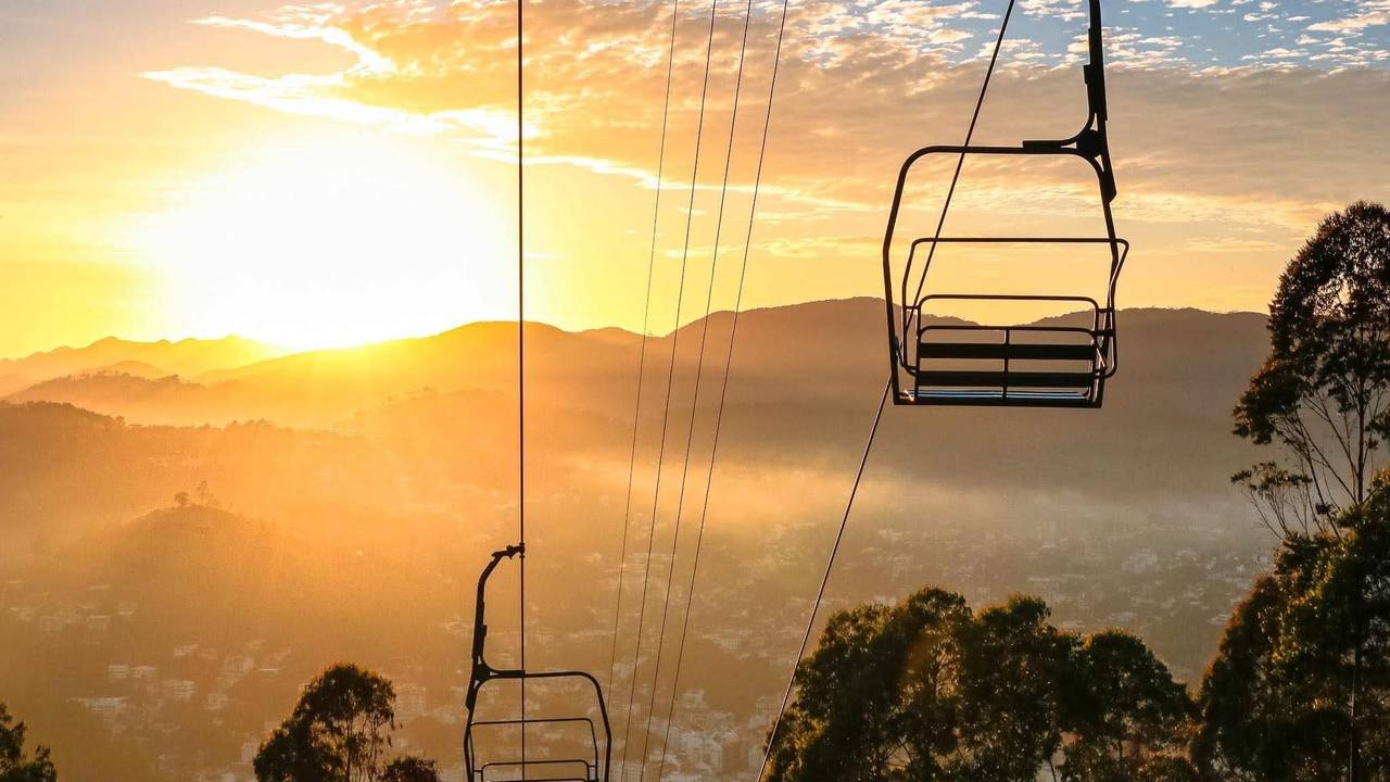 Teleférico ao nascer do sol sobre montanhas e cidade, maior sistema urbano do Brasil.