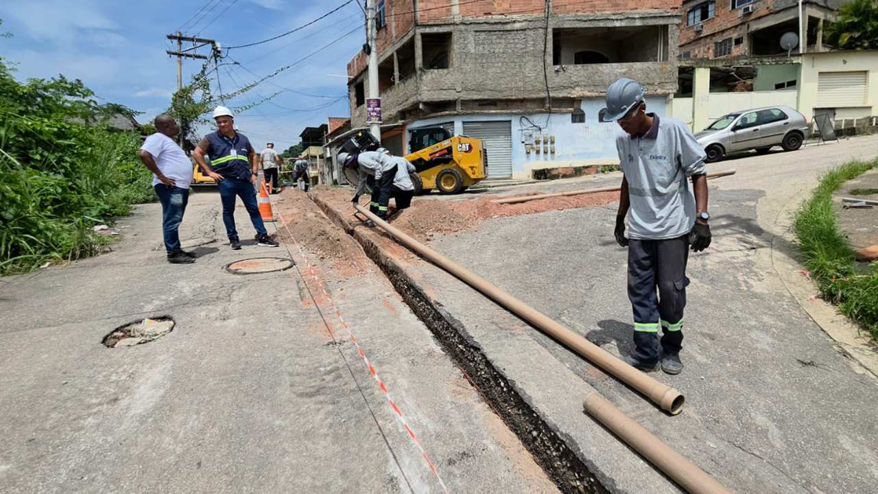 Trabalhadores instalam tubulação em rua, possivelmente relacionada a problemas de abastecimento de água.