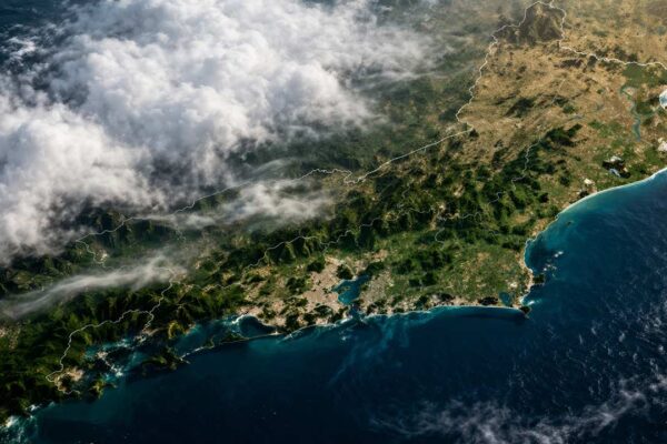 Vista aérea da costa do Rio de Janeiro com nuvens e vegetação exuberante.
