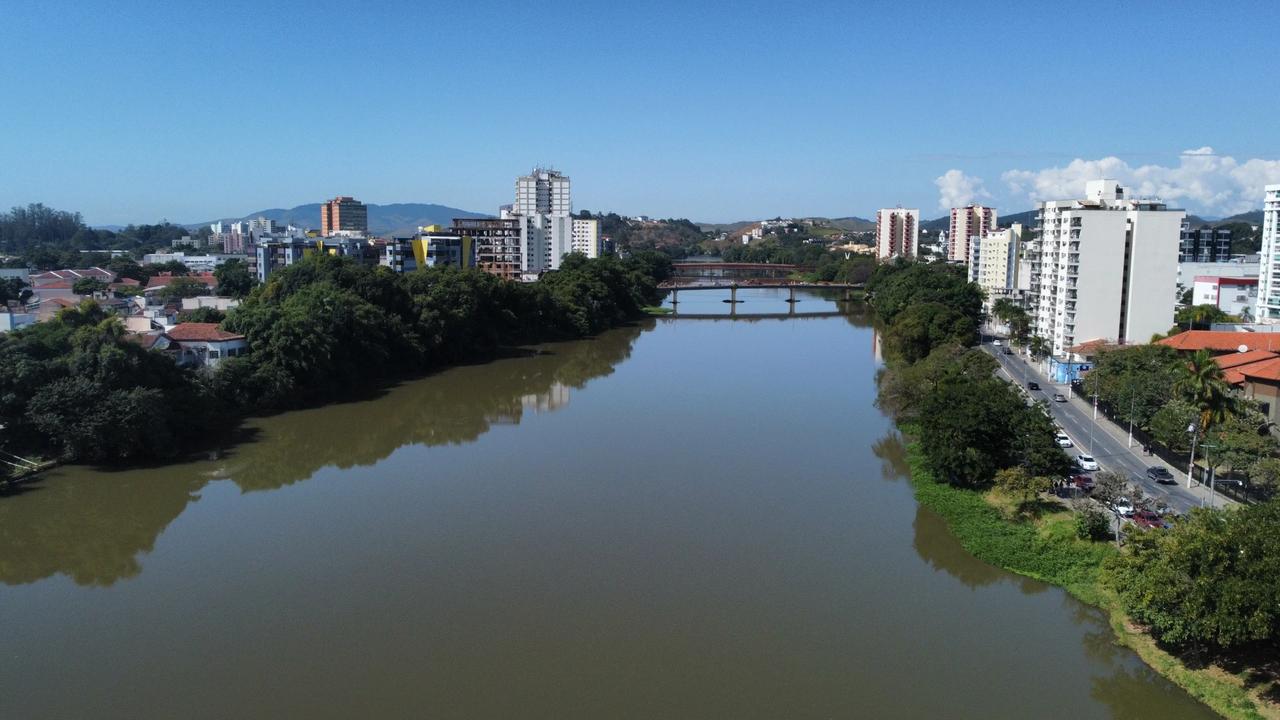 Vista panorâmica de Resende, cidade fluminense, com rio, prédios e céu azul.