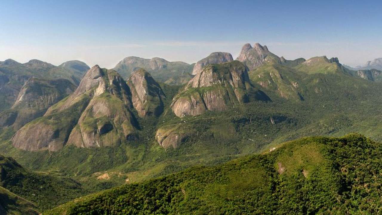 Vista panorâmica do Parque Estadual dos Três Picos com montanhas e vegetação exuberante.