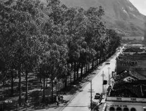 Vista antiga dos arredores da Praça Getúlio Vargas, com avenida arborizada e montanhas de Nova Friburgo