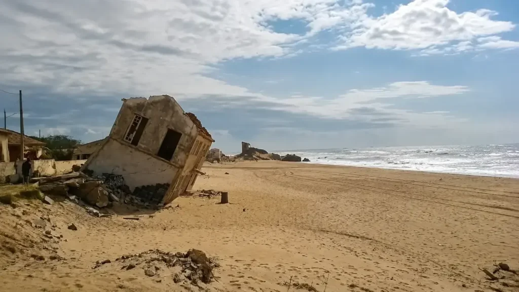 Casa destruída e inclinada próxima ao oceano na praia de Atafona