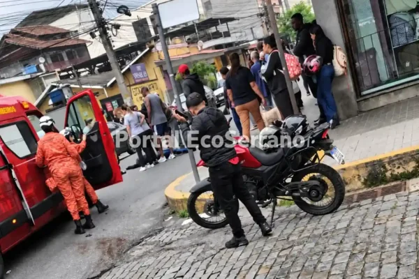 Bombeiro ao lado de veículo de resgate, com motocicleta e pessoas nas proximidades.