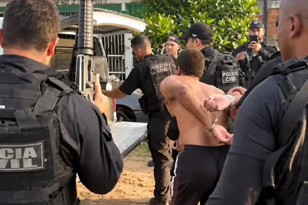 Ronaldo Henrique Souza Peixoto usando camiseta cinza diante de uma parede texturizada.