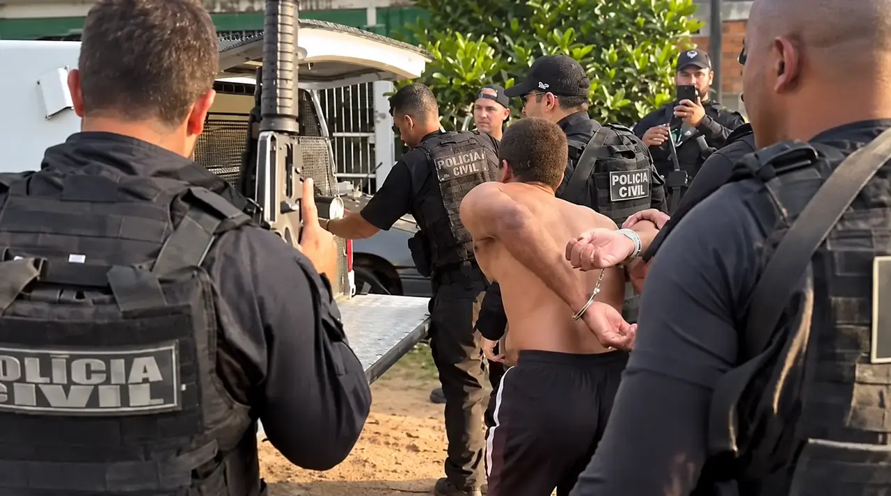 Ronaldo Henrique Souza Peixoto usando camiseta cinza diante de uma parede texturizada.