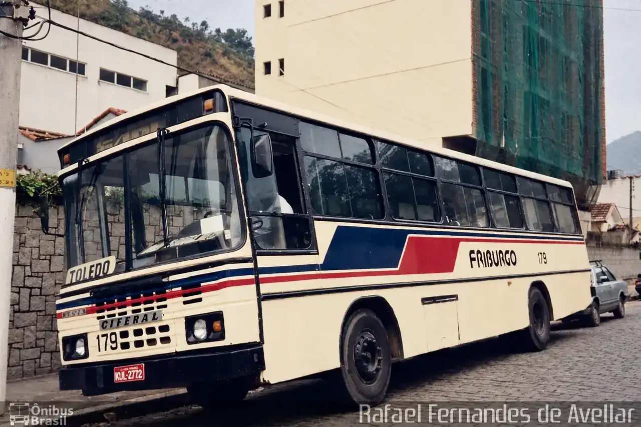 Ônibus 179 com letreiro Toledo e identificação Friburgo, estacionado em rua de paralelepípedos.