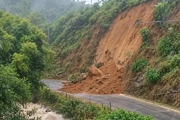 Terra e pedras de uma encosta deslizada atingem a Estrada de Boa Esperança, junto a um curso d’água.