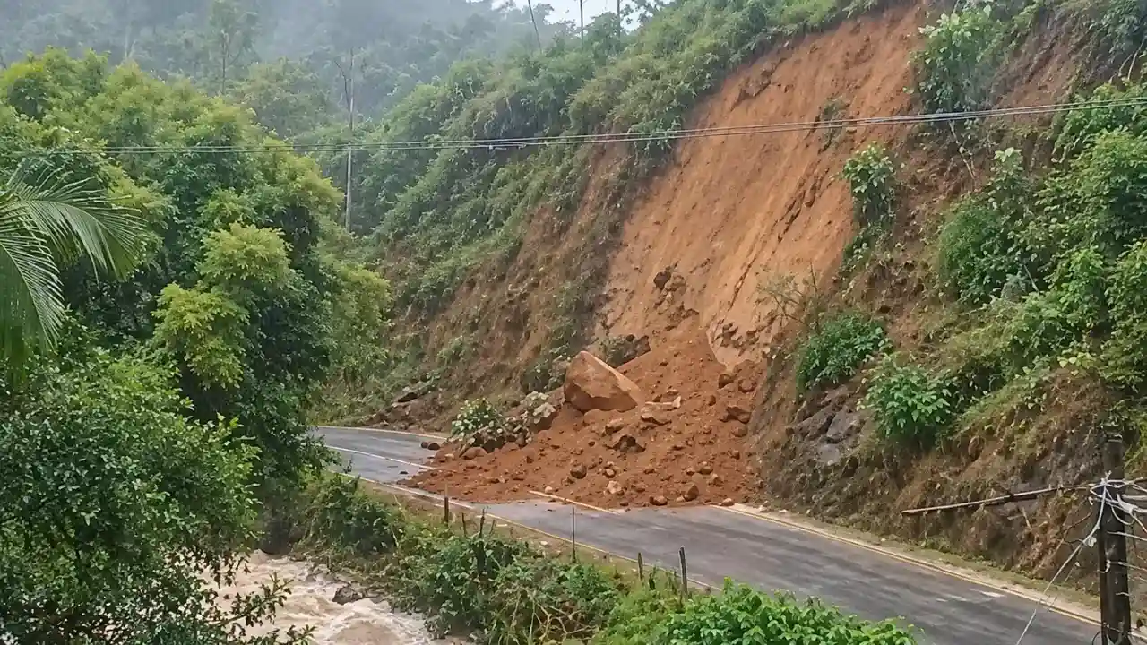 Terra e pedras de uma encosta deslizada atingem a Estrada de Boa Esperança, junto a um curso d’água.